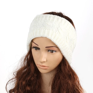 Detail of white cable knit ear warmer headband showing thick woolen texture and pattern