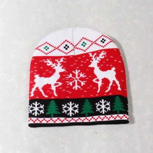 Detailed view of the Christmas knit pattern featuring reindeer and snowflakes on red beanie