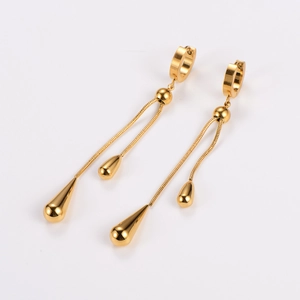 Detail view of golden water drop tassel earrings with polished metallic snake chains