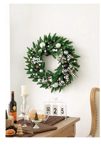 Vue détaillée d'une couronne de Noël avec boules argentées et LED sur un mur blanc