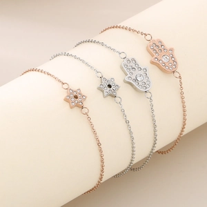 Détail de bracelets Main de Fatma et hexagramme en or rose et argent avec cristaux