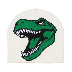 Close-up of the knitted texture and green dinosaur jacquard pattern on the white beanie