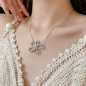 Gros plan d'un collier pendentif fleur évidée en argent avec zircons sur un mannequin