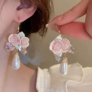 Elegant floral drop earrings with pink ceramic rose and teardrop pearl on gold hooks