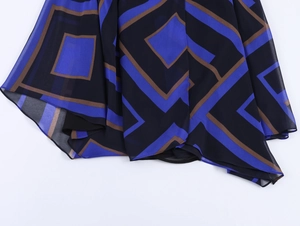 Detailansicht eines Chiffonrocks mit blau-braunem asymmetrischem geometrischem Muster
