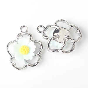 Detailed macro view showing the front and back of a white alloy flower charm with silver frame