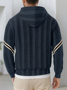 Detailed close-up of dark blue knitted hoodie texture with black and white sleeve stripes
