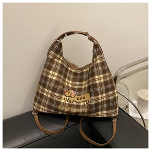 Detail of checkered canvas tote bag with puppy embroidery and brown PU leather straps