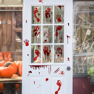 Close-up of Halloween bloody handprints and footprints stickers on a white glass door