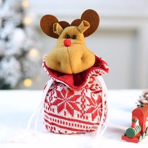 Red and white knitted Christmas gift bag with a plush elk on festive background