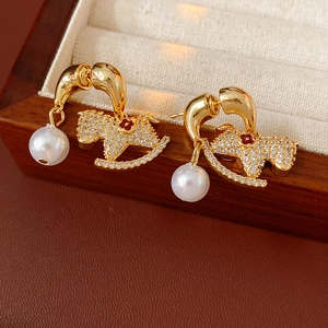 Macro detail of rocking horse earrings with crystals, red flower and white pearls