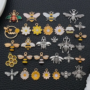 DIY enamel bee and daisy alloy pendants for handmade jewelry crafting on black background