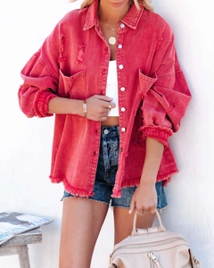 Close-up of red denim jacket featuring distressed ripped details and raw fringe edges