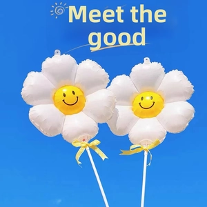 Close-up of daisy foil balloon with a smiling face and yellow bow against clear blue sky