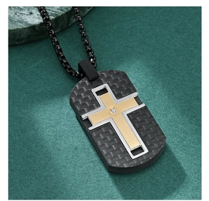 Detailed macro view of black carbon fiber dog tag pendant with gold and silver crosses