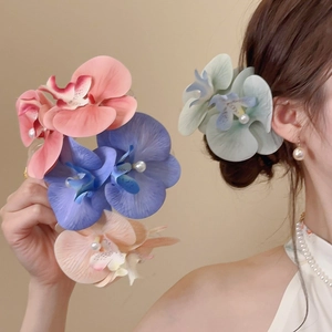Detail of floral fabric hair clips with pearls in pink, blue, and orange colors