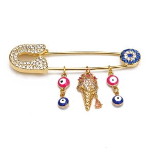 Detailed close-up of gold ice cream brooch with evil eye charm and sparkling crystals