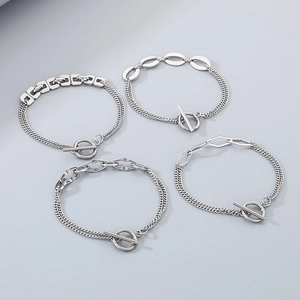 Silver geometric chain bracelet with OT toggle clasp on a minimalist grey background