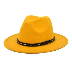 Detail of yellow wool fedora hat featuring a black leather band with gold metal studs