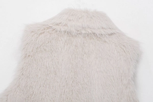 Detailaufnahme von Kragen und Rücken einer flauschigen Kunstfellweste in hellem Beige