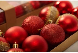 Macro shot of red matte and glitter Christmas ball ornaments in a kraft paper gift box