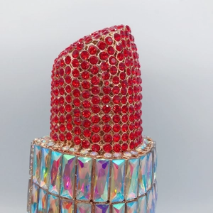 Macro view of red and AB crystal rhinestones on a lipstick shaped evening clutch bag