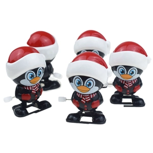Detailed view of five wind-up penguins with Christmas hats and red scarves toy set