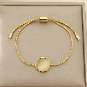 Détail du bracelet chaîne serpent dorée avec opale blanche et fermoir coulissant réglable