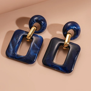 Detail showing blue marble acrylic geometric hollow rectangle earrings on beige background