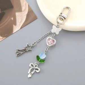 Y2K flower bow keychain with metallic star and heart charms on a minimalist background