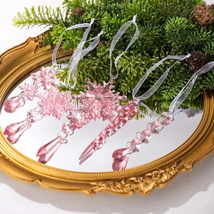 Macro detail of pink acrylic snowflake and icicle ornaments on a vintage tray