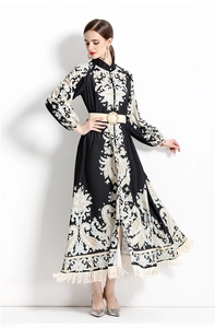 Détail de la robe noire à manches longues avec motif paisley, ceinture et franges