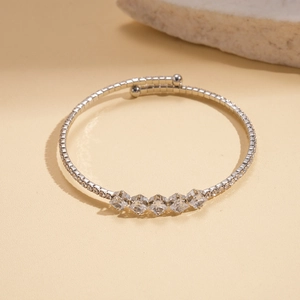 Detailed close-up of a silver stretch bracelet with five square sparkling zircon stones