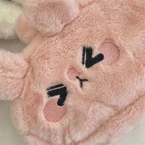 Gros plan d'une trousse en peluche rose avec broderie lapin et texture douce