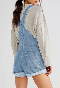 Detailed back view of light blue denim overalls with large pockets and triangle strap join