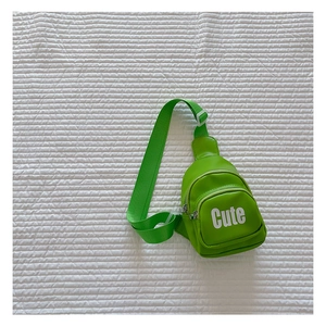 Detail showing bright green leather chest bag with adjustable strap and Cute print