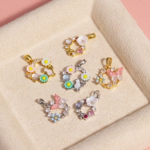 Detailed view of floral zircon pendants with butterflies and shell petals on jewelry tray