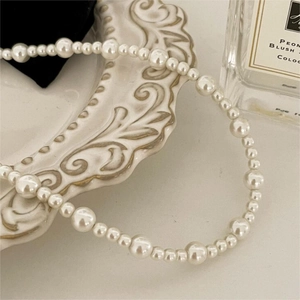 Elegant 925 sterling silver pearl necklace displayed on an artistic vintage relief plate