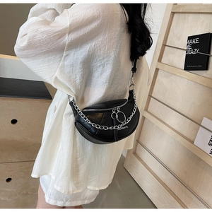 Model wearing a black textured PU shoulder bag with silver chain and dual ring zippers