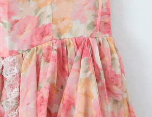 Detalle de tela de gasa con flores rosas y ribete de encaje blanco en un vestido Lolita