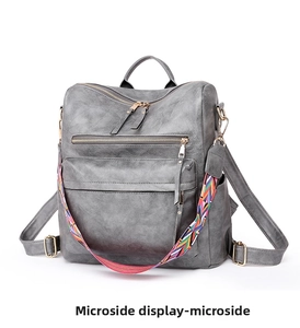 Side view of dark gray vintage PU leather backpack with a colorful woven strap