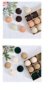 Détail de boules de Noël floquées de 6 cm aux tons terreux sur des branches de sapin