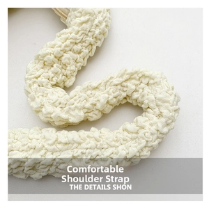 Detailed close-up of the puffy cloud pleated shoulder strap in cream white fabric