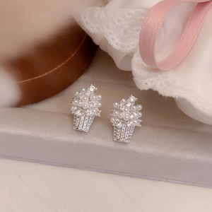 Close-up macro detail of elegant flower basket stud earrings with pearls and zircons