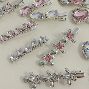 Flat lay of silver alloy hair clips with pink and iridescent rhinestones in star and heart shapes