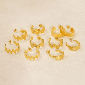 Detailed view of five pairs of assorted golden geometric C-shaped stainless steel earrings