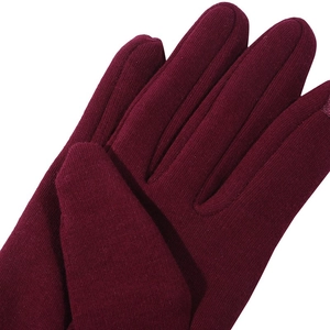 Macro detail of the wine red knitted gloves showing thick thermal fleece texture