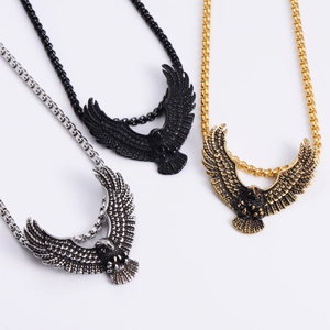 Detailed view of eagle pendants in silver, black, and gold with pearl square chains