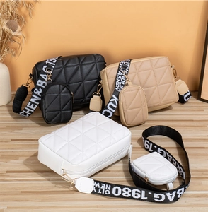 Détail du sac bandoulière matelassé avec sangle large imprimée et petit porte-monnaie