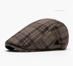 Detail of khaki plaid wool beret cap showing texture and brown leather strap